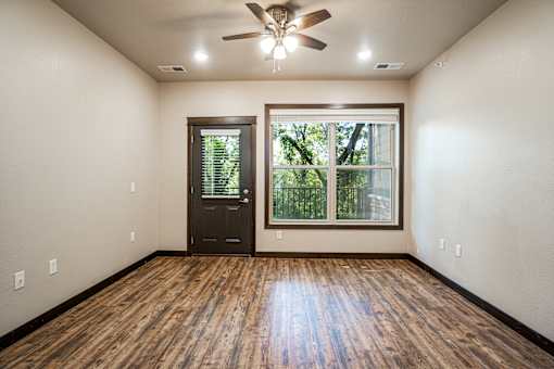 A room with a wooden floor and a ceiling fan.