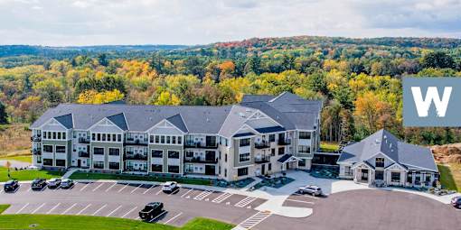 A large white building with a parking lot in front of it.