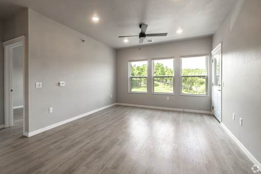 A spacious room with a ceiling fan and sliding glass doors.