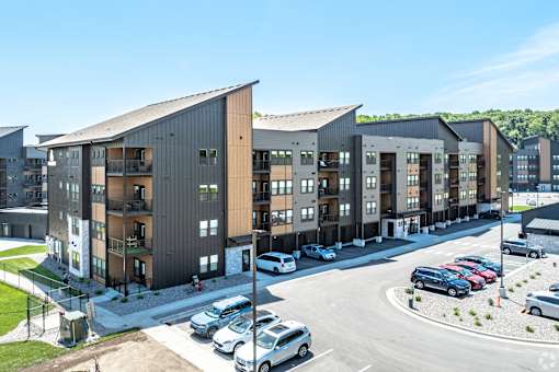 A parking lot with cars and apartment buildings in the background.