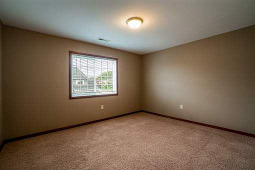 A room with a window and carpeted floor.