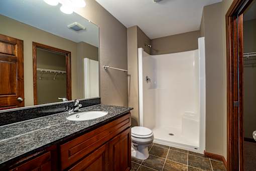 A bathroom with a sink, toilet, and shower.