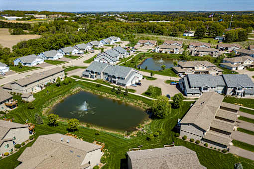 A bird's eye view of a residential neighborhood with houses and a fountain.
