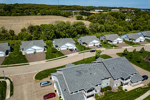 A row of houses with cars parked in front.