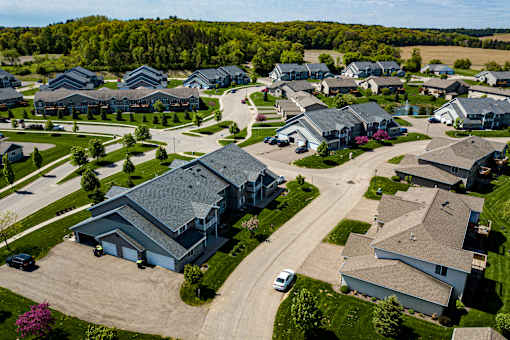 A suburban neighborhood with houses and a car parked on the street.