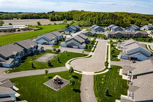 A bird's eye view of a residential neighborhood with houses and a central park.