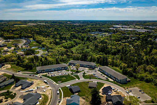 A bird's eye view of a large building complex surrounded by a green landscape.