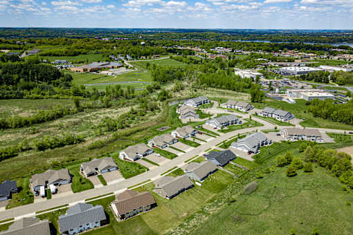 A bird's eye view of a residential area with houses and green lawns.