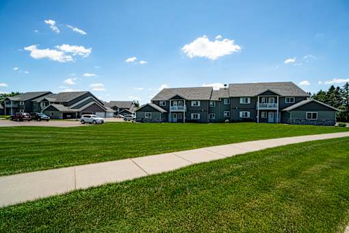 A row of houses with a sidewalk in front.