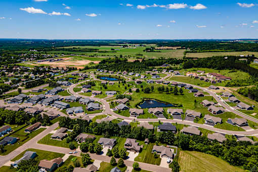 A bird's eye view of a residential neighborhood with houses and a lake.