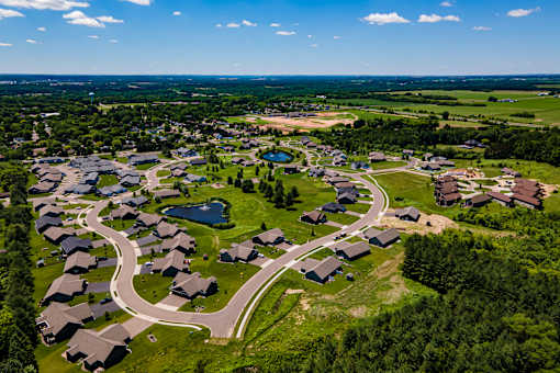 A bird's eye view of a residential area with houses and a winding road.