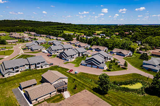 A bird's eye view of a residential area with houses and green lawns.