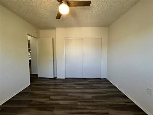 A room with a ceiling fan and two doors.