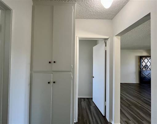 A white cabinet with two doors and two drawers is in a room with wood flooring.