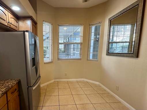 A kitchen with a refrigerator, cabinets, and a countertop.