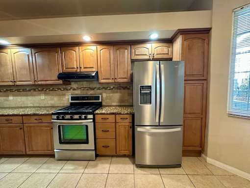 A kitchen with a stove, oven, and refrigerator.