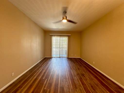 A room with wooden floors and a ceiling fan.