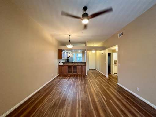 A room with wooden floors and a ceiling fan.