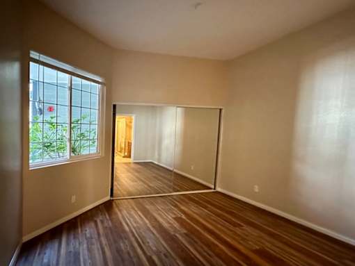 A room with wooden floors and a large window.