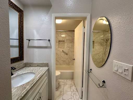 A bathroom with a marble countertop and a white door.
