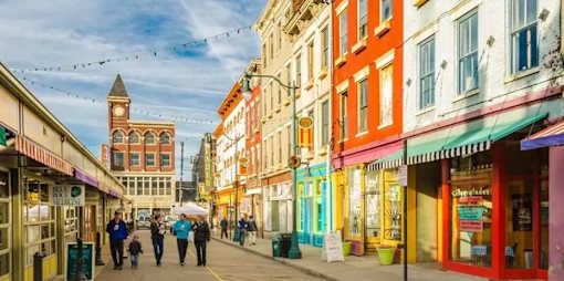 A street scene with people walking and colorful buildings.