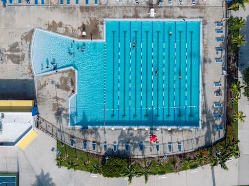 A large blue swimming pool with people in it.