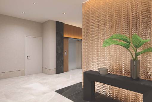 A plant in a vase sits on a table in front of a wall with a textured pattern.