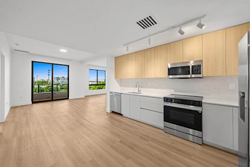 A modern kitchen with wooden cabinets and stainless steel appliances.