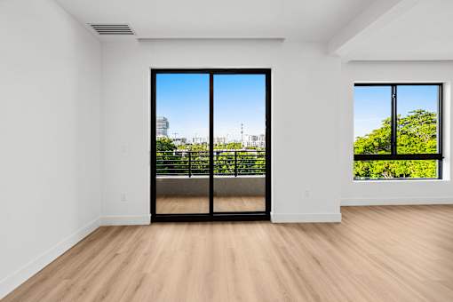 A room with a view of the city through a large window.