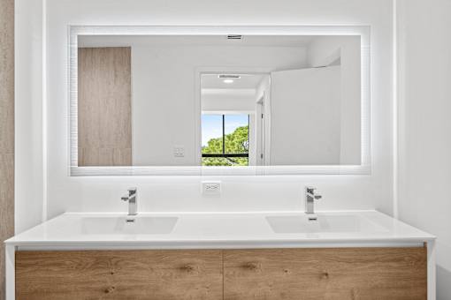 A bathroom with two sinks and a large mirror.