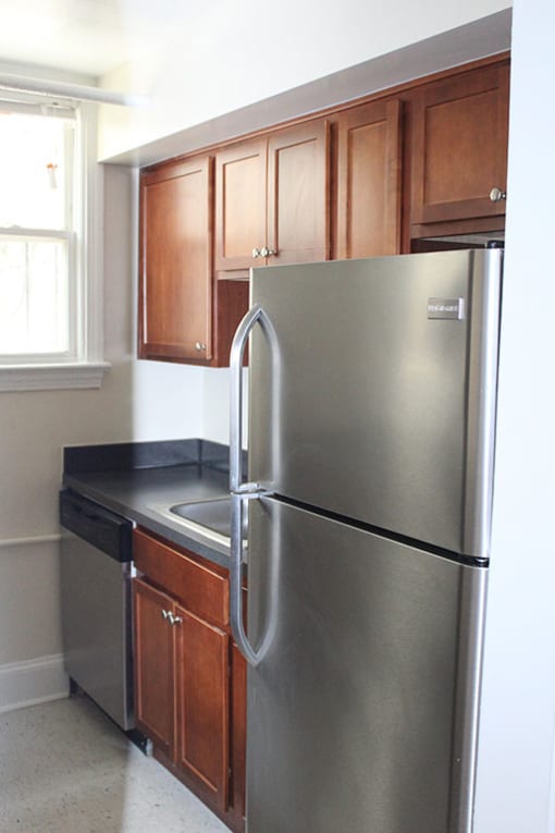 a kitchen with a stainless steel refrigerator and wooden cabinets