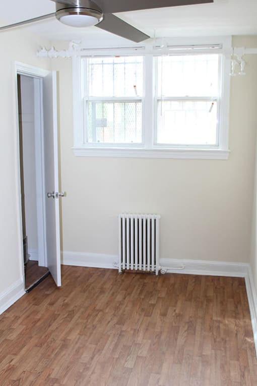 an empty room with a radiator and a window