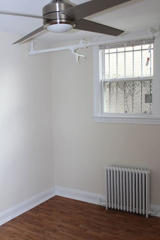 a room with a ceiling fan and a radiator