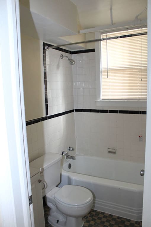 a white toilet sitting next to a white bath tub