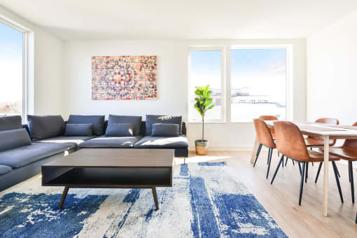 a living room with white walls and a blue rug