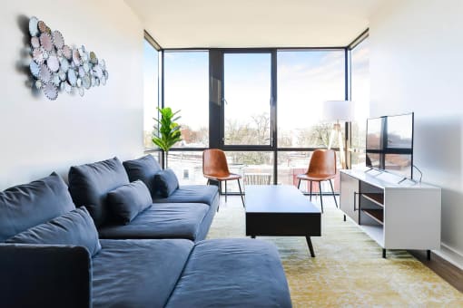 a living room with a blue couch and a large window