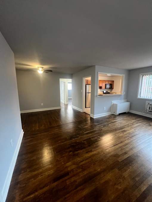 A room with wooden floors and a white wall.