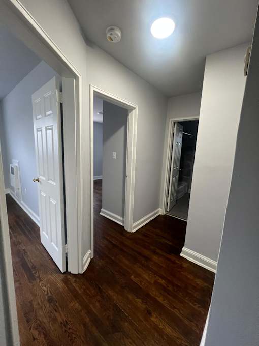 A room with a white door and a light on the ceiling.