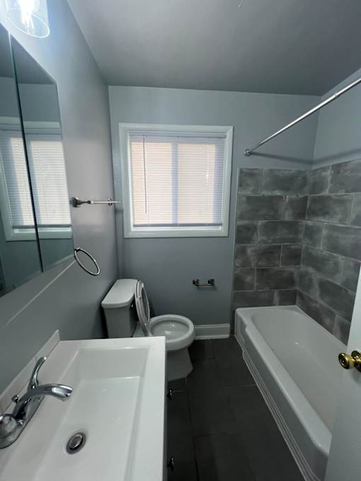 A bathroom with a white sink, toilet, and bathtub.