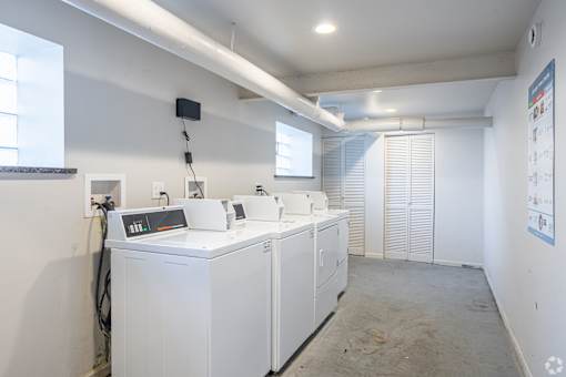 A clean, empty room with white appliances and a whiteboard on the wall.