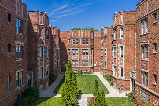 A view of a courtyard surrounded by red brick buildings.