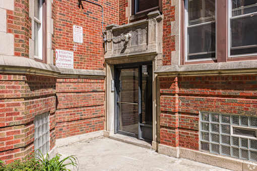 A red brick building with a sign that says "No trespassing" on the wall.