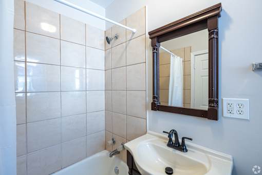 A bathroom with a white sink and a white bathtub.