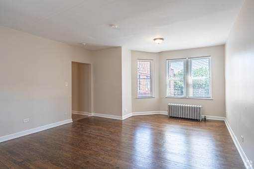 Empty room with wooden floors and white walls.