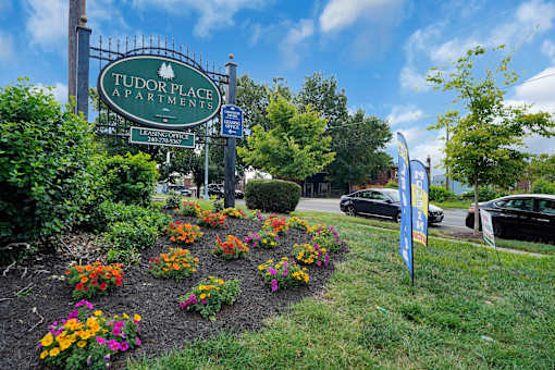 A sign for Tudor Place Apartment reads "French Country".