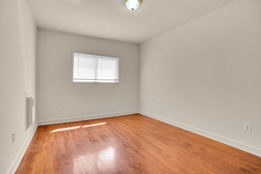 A room with wooden flooring and a window.