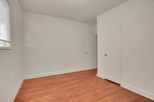 A room with wooden floors and white walls.