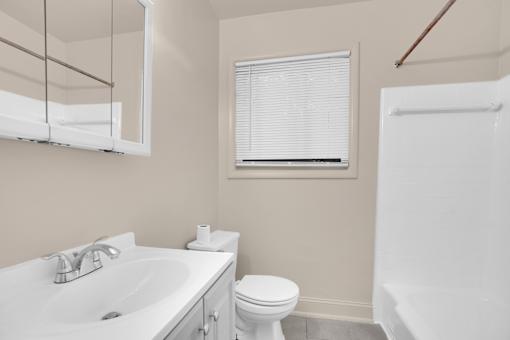 A white toilet sits next to a sink in a bathroom.