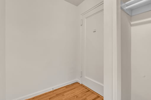 A white door in a room with wooden flooring.