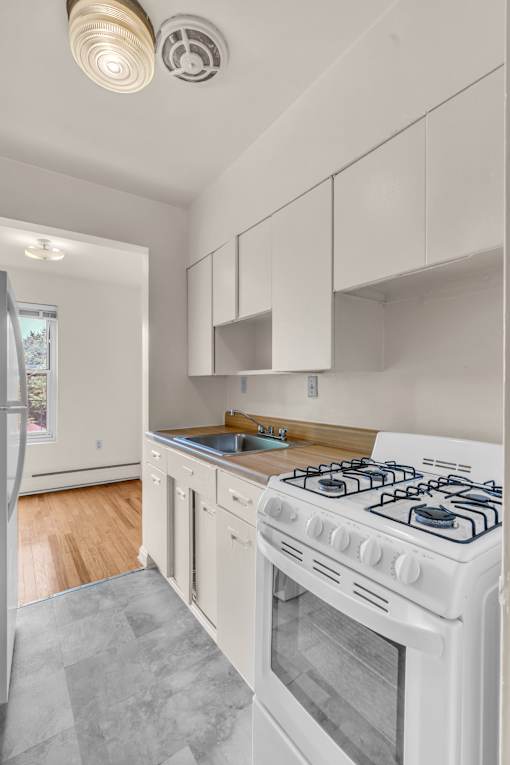 A white gas stove in a kitchen with a white oven.